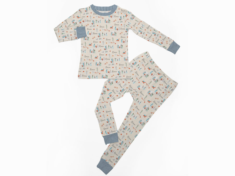 Little kid wearing personalized Christmas PJ's with nativity scene images and his or her name on soft ivory material.