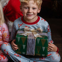 child wearing personalized christmas pajamas with santa on skateboards on blue background with red cuffs