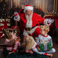 child wearing personalized christmas pajamas with santa on skateboards on blue background with red cuffs