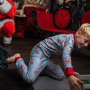child wearing personalized christmas pajamas with santa on skateboards on blue background with red cuffs