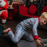 child wearing personalized christmas pajamas with santa on skateboards on blue background with red cuffs