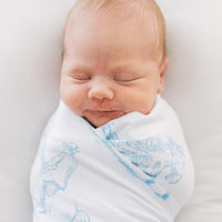 baby boy swaddled in blue western toile print white knit baby blanket with name