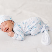 baby boy in tie bottom baby gown with light blue western toile print personalized with name and matching knotted hat