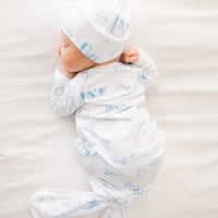 baby boy in tie bottom baby gown with light blue western toile print personalized with name and matching knotted hat