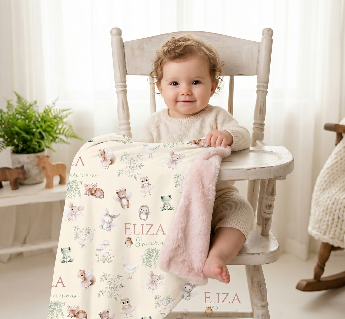 Personalized Woodland Fairy Baby Deluxe blanket with pink fur backing featuring woodland animals, fairies, and a baby girl's name, displayed with a toddler in a nursery setting.