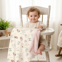 Personalized Woodland Fairy Baby Deluxe blanket with pink fur backing featuring woodland animals, fairies, and a baby girl's name, displayed with a toddler in a nursery setting.