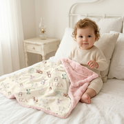 Personalized Woodland Fairy Baby Deluxe blanket with pink fur backing featuring woodland animals, fairies, and a baby girl's name, displayed with a toddler in a nursery setting.