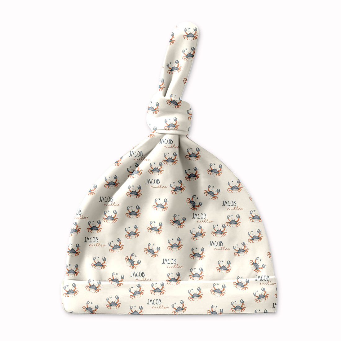 A white baby hat with a pattern of small crabs printed on it.