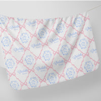a white fabric with a repeating pattern of pink bows and the name "Charlotte" written in blue.
