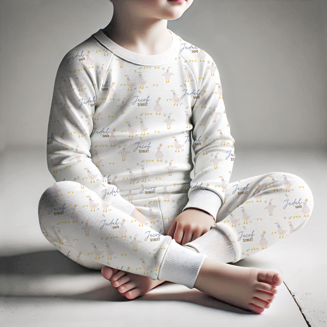 white personalized pajamas with geese and blue ribbons on little boy