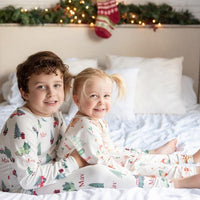 little boy wearing personalized Christmas Truck PJ's, nostalgic baby Christmas sleepwear. Featuring vintage trucks carrying Christmas trees.