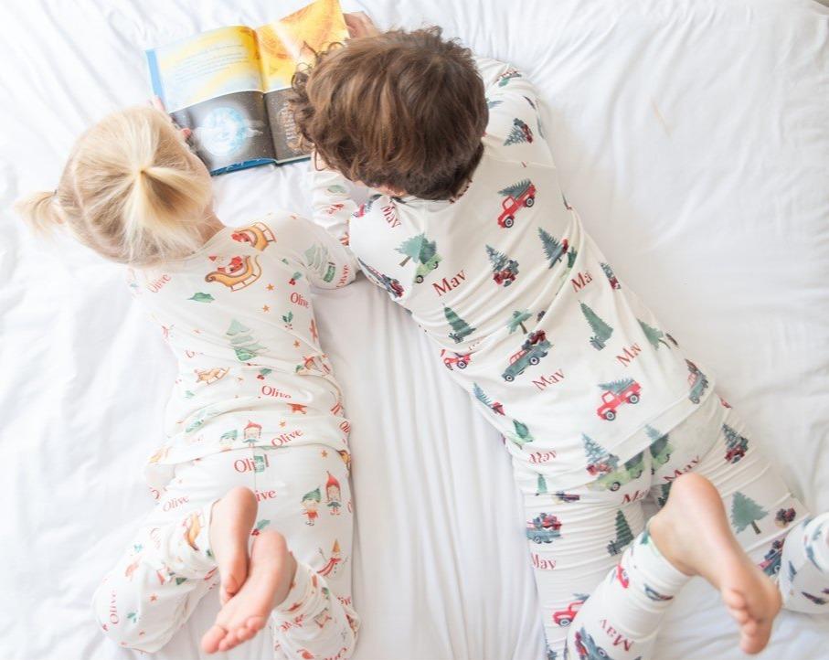 little boy wearing personalized Christmas Truck PJ's, nostalgic baby Christmas sleepwear. Featuring vintage trucks carrying Christmas trees.