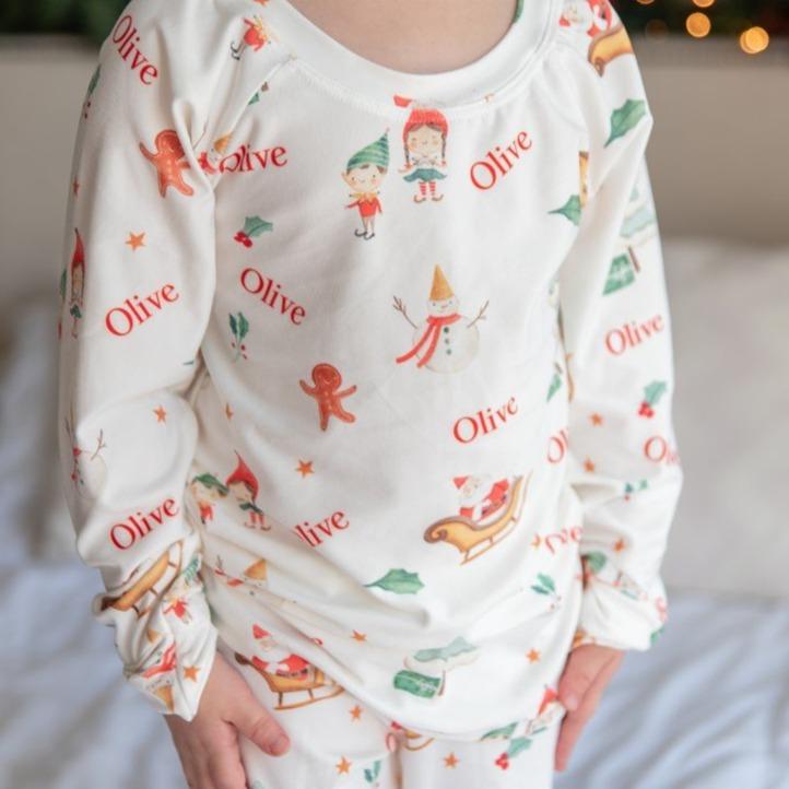 Young boy wearing Gingerbread Christmas Pajamas that are personalized with the boy's name.