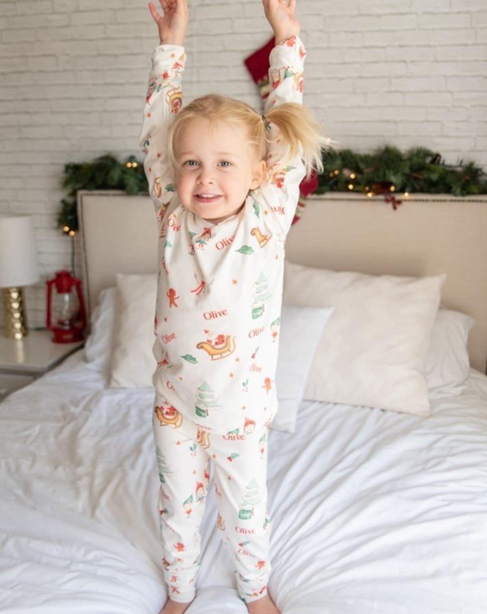 Young girl jumping on the bed in her new Gingerbread Christmas Pajamas. 