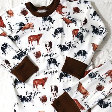 The design on our personalized kids cow pajamas. The design has brown cows with white spots and white cows with black spots. 