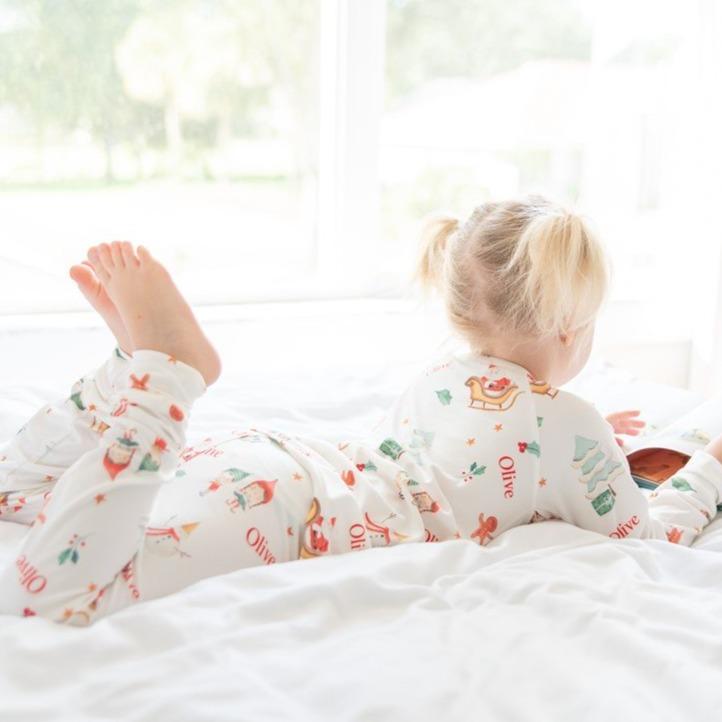 Little girl laying on the bed wearing her new Gingerbread Christmas Pajamas. 